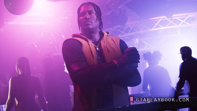 Dre’Quan Priest — Op een dansvloer met gekruiste armen in een oranje