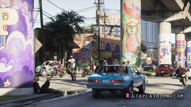 Vice City — Straat met beschilderde viaductpijlers, crossmotoren, een blauwe sedan en